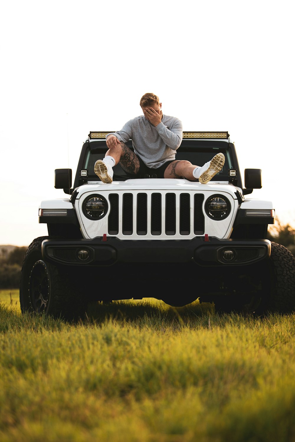 couple sitting on white jeep wrangler