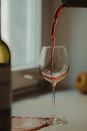 Close-up of a sommelier pouring red wine into a glass on a ship