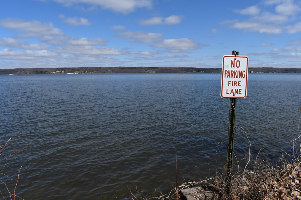 no smoking sign near body of water during daytime