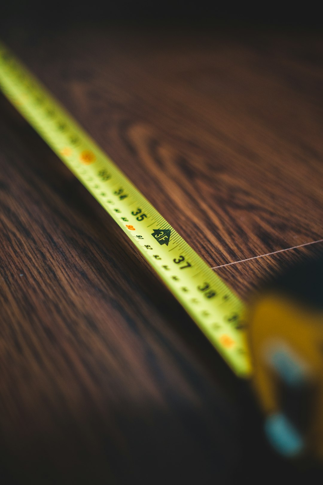 yellow measuring tape on brown wooden table