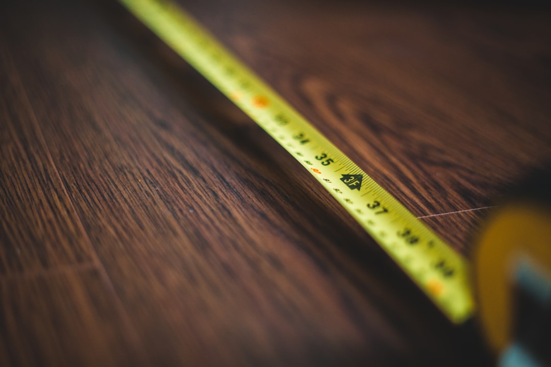 yellow measuring tape on brown wooden table