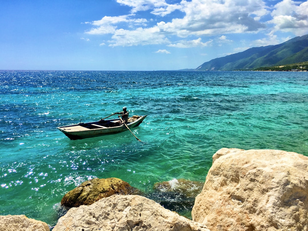 man in red shirt riding on boat on sea during daytime