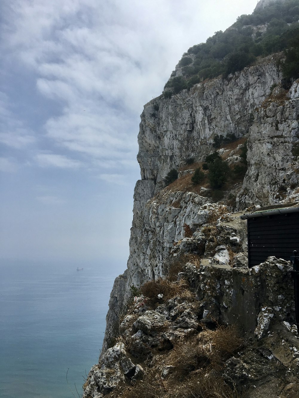 Montagna rocciosa grigia accanto allo specchio d'acqua durante il giorno