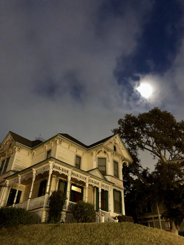 An old Victorian house glowing softly at twilight, hinting at ghostly secrets within.
