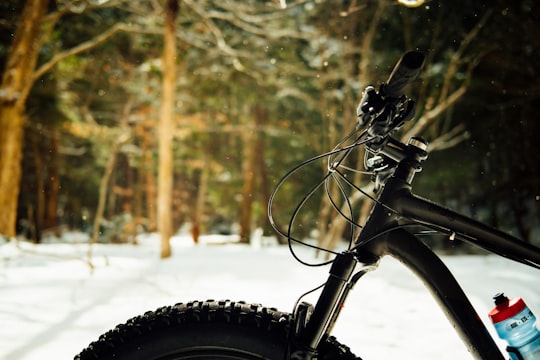 black bicycle on snow covered ground during daytime in Nova Scotia Canada