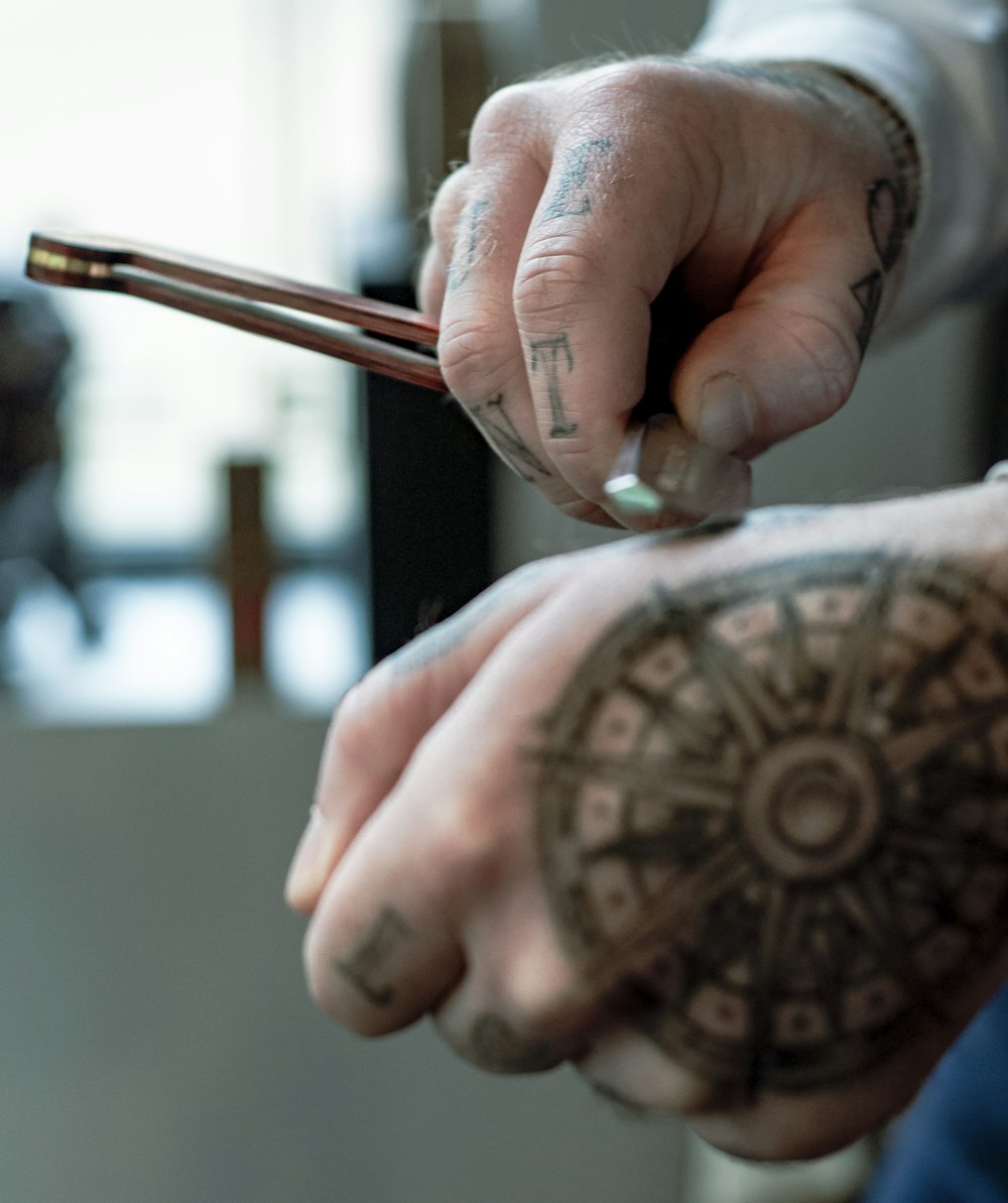 person holding silver and brown pen