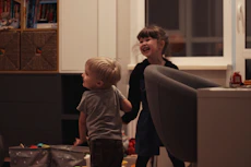 A smiling therapist engaging with a child using playful educational toys.