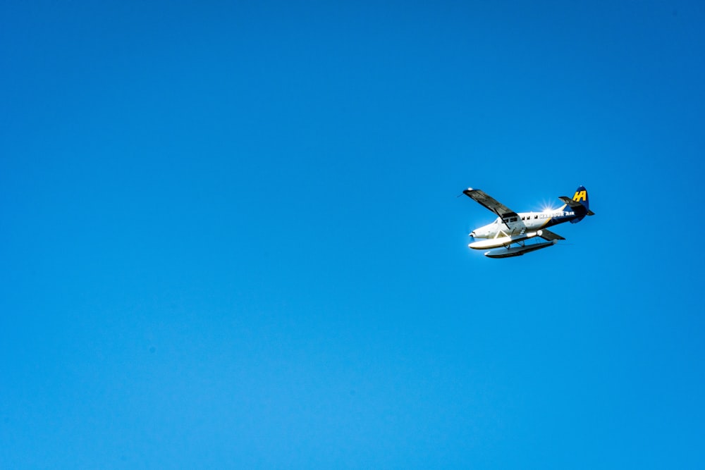 white and blue airplane in mid air during daytime