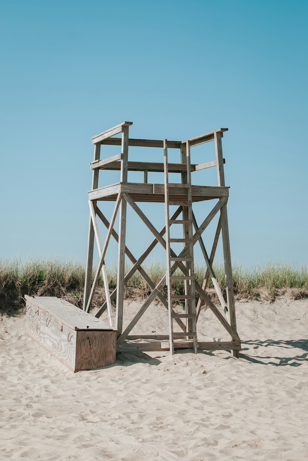 torre de madeira cinzenta na areia marrom durante o dia