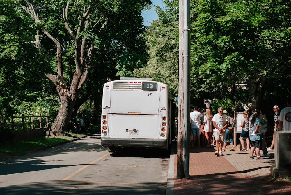 people walking on sidewalk near white van during daytime