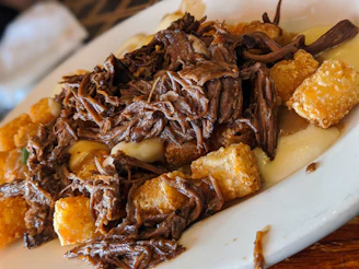 An inviting dish of slow-cooked beef with rich sauce and side potatoes.