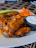 Plate of crispy boneless wings with a side of dipping sauce and fresh celery sticks.