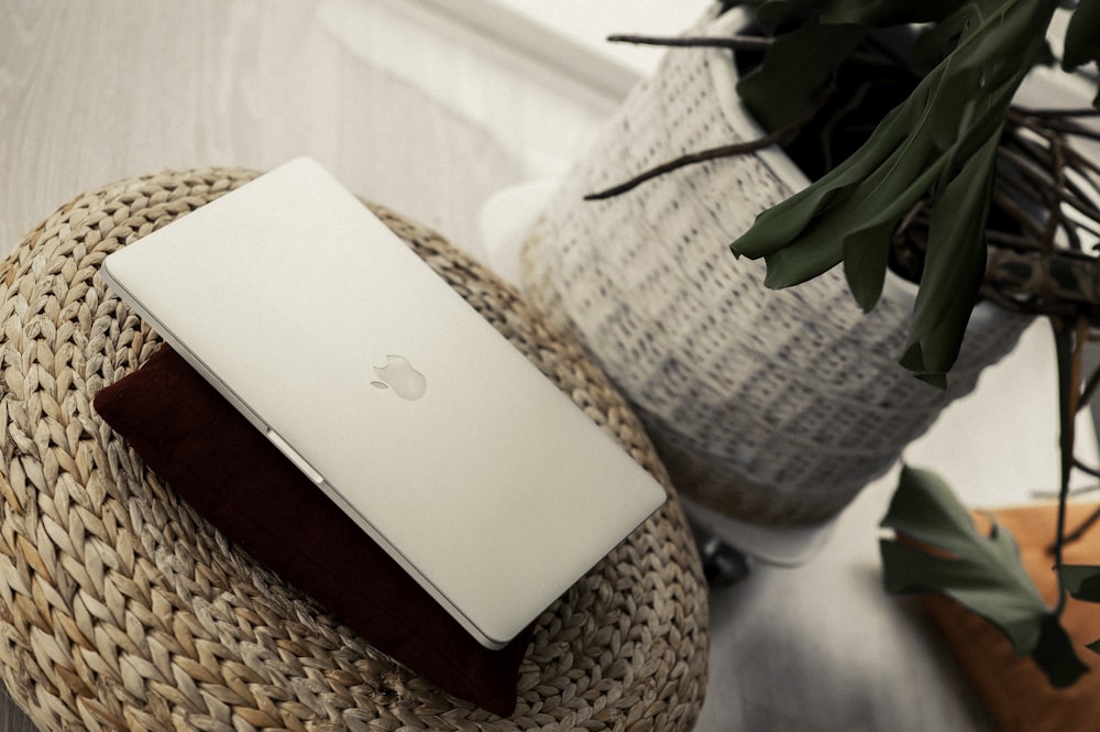 silver macbook on brown woven basket