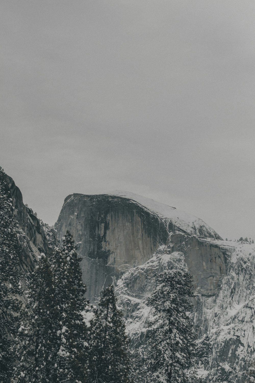 snow covered mountain under cloudy sky during daytime