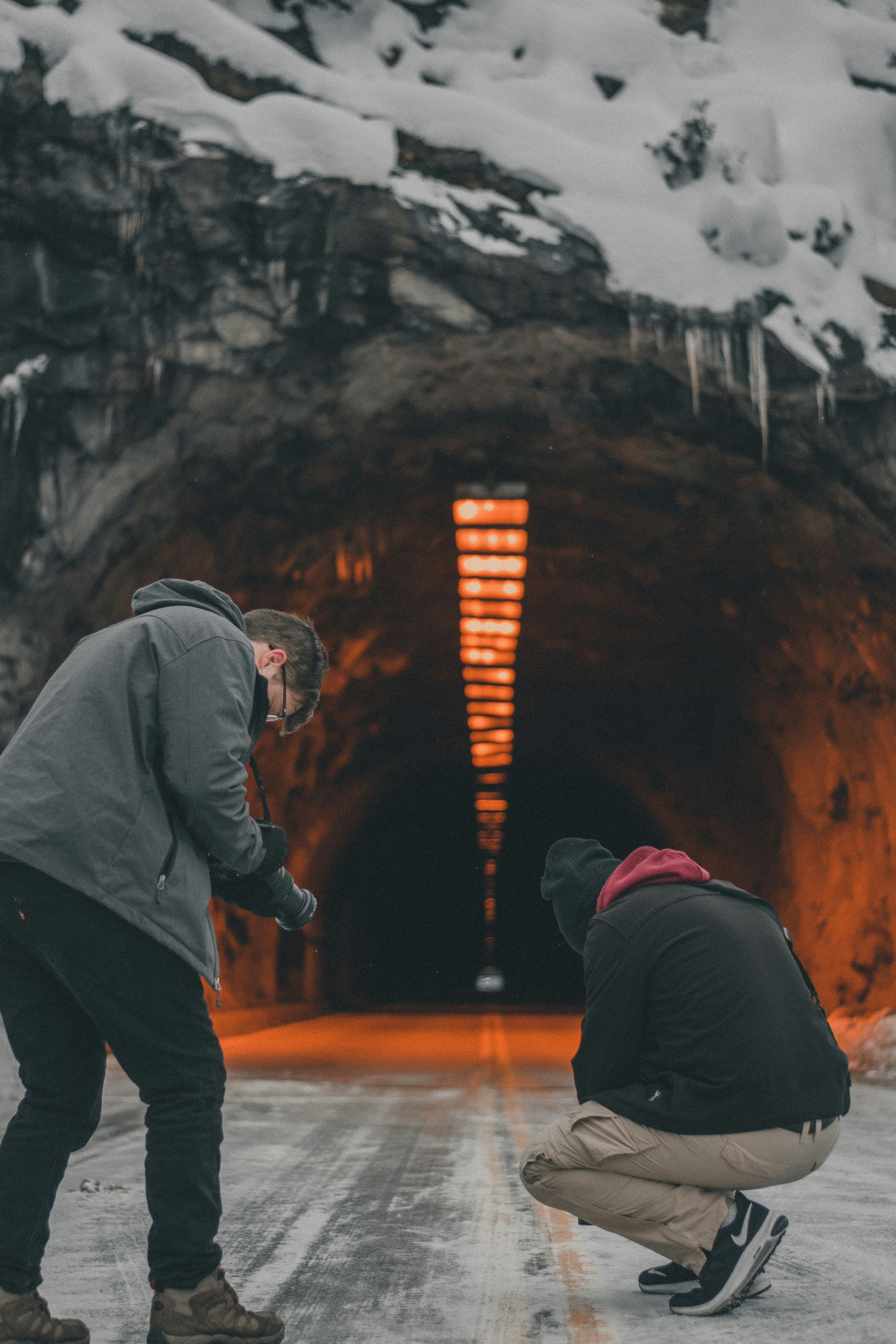 man in gray hoodie and black pants standing on brown wooden floor