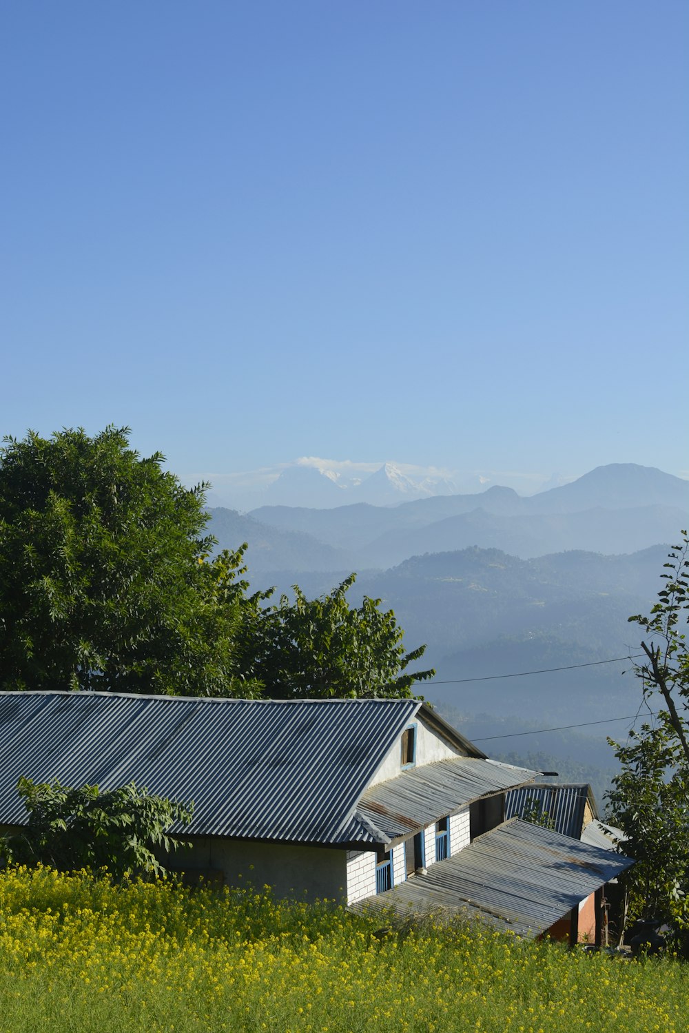 white and brown house near green trees and mountains during daytime