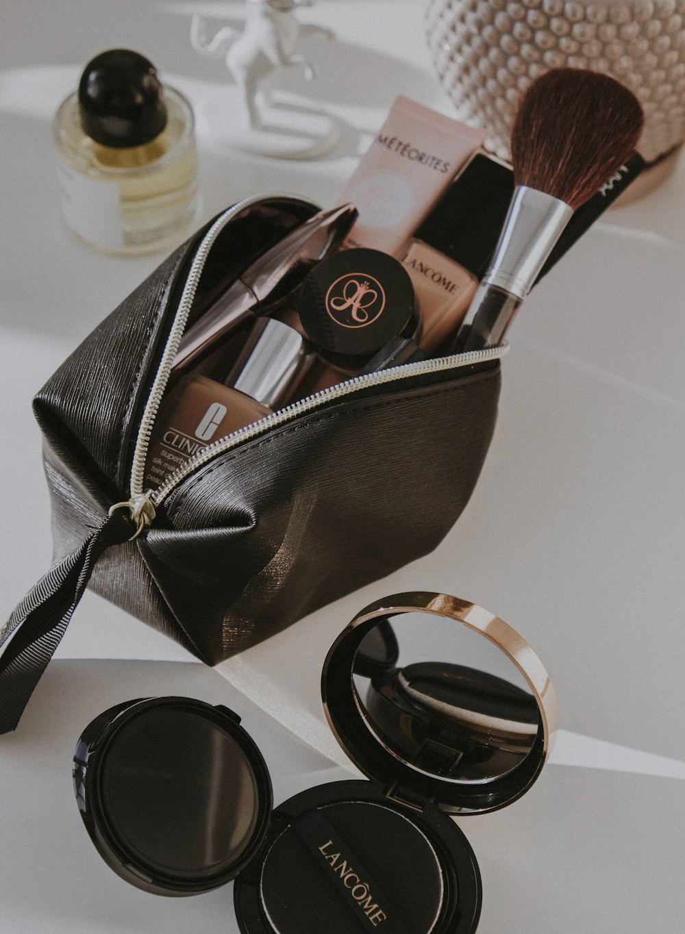 A small makeup-style zip pouch on a dressing table