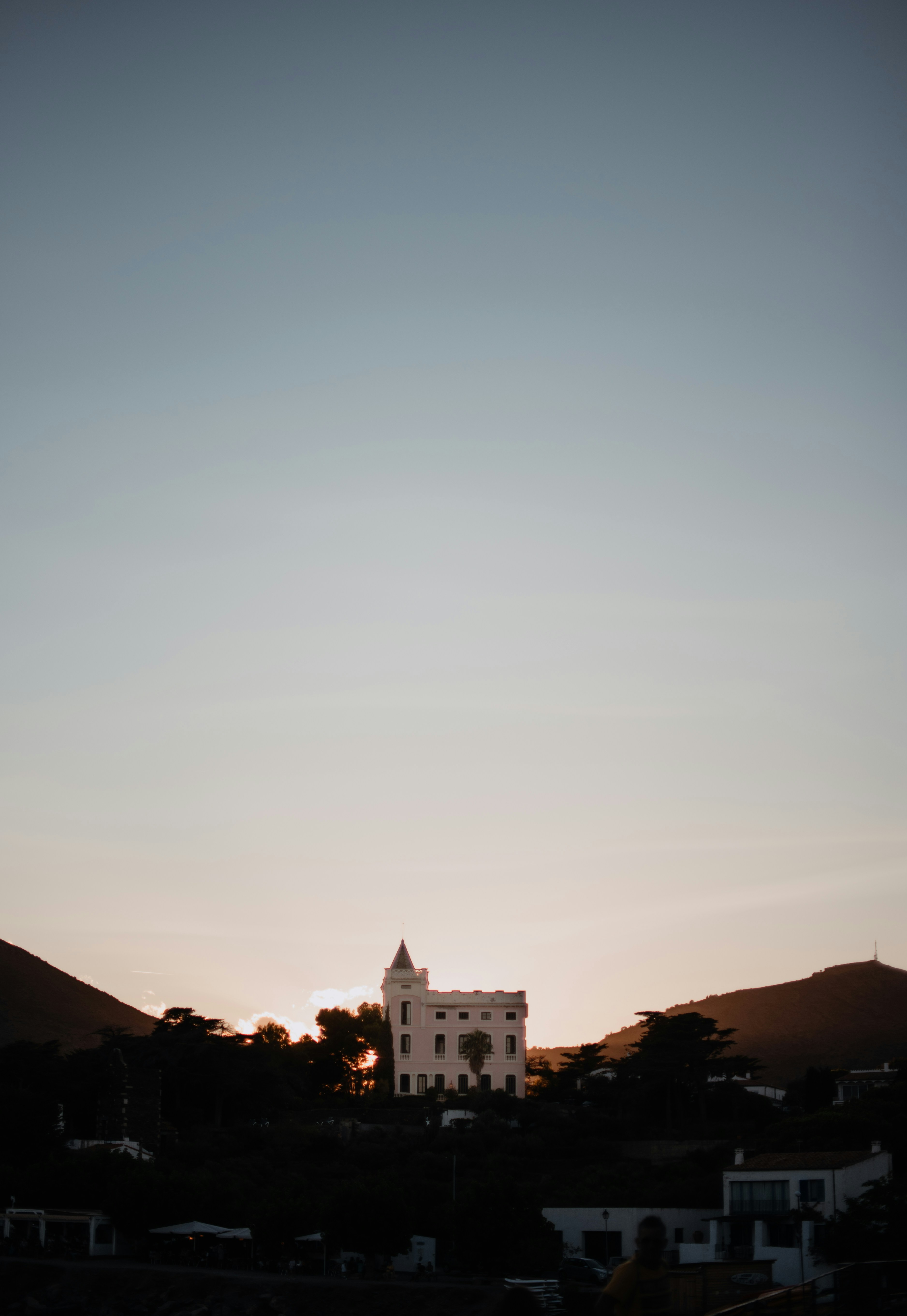 Weißes Betongebäude unter blauem Himmel tagsüber