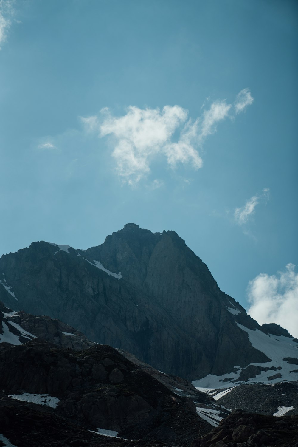 rocky mountain under white clouds and blue sky during daytime