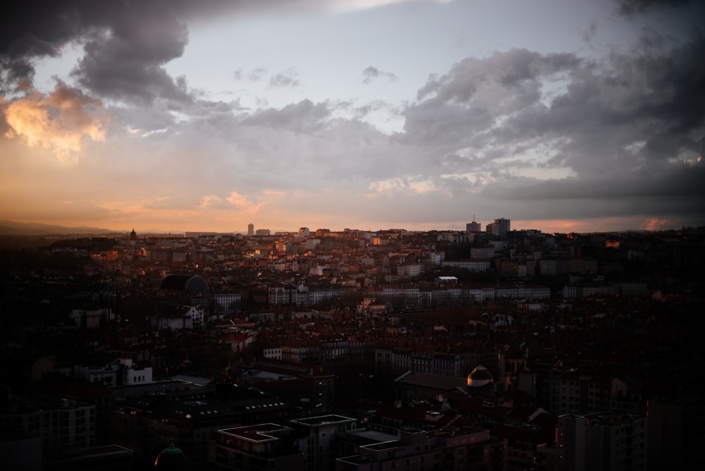 city with high rise buildings under white clouds during daytime