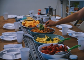 person holding green plastic bowl with food