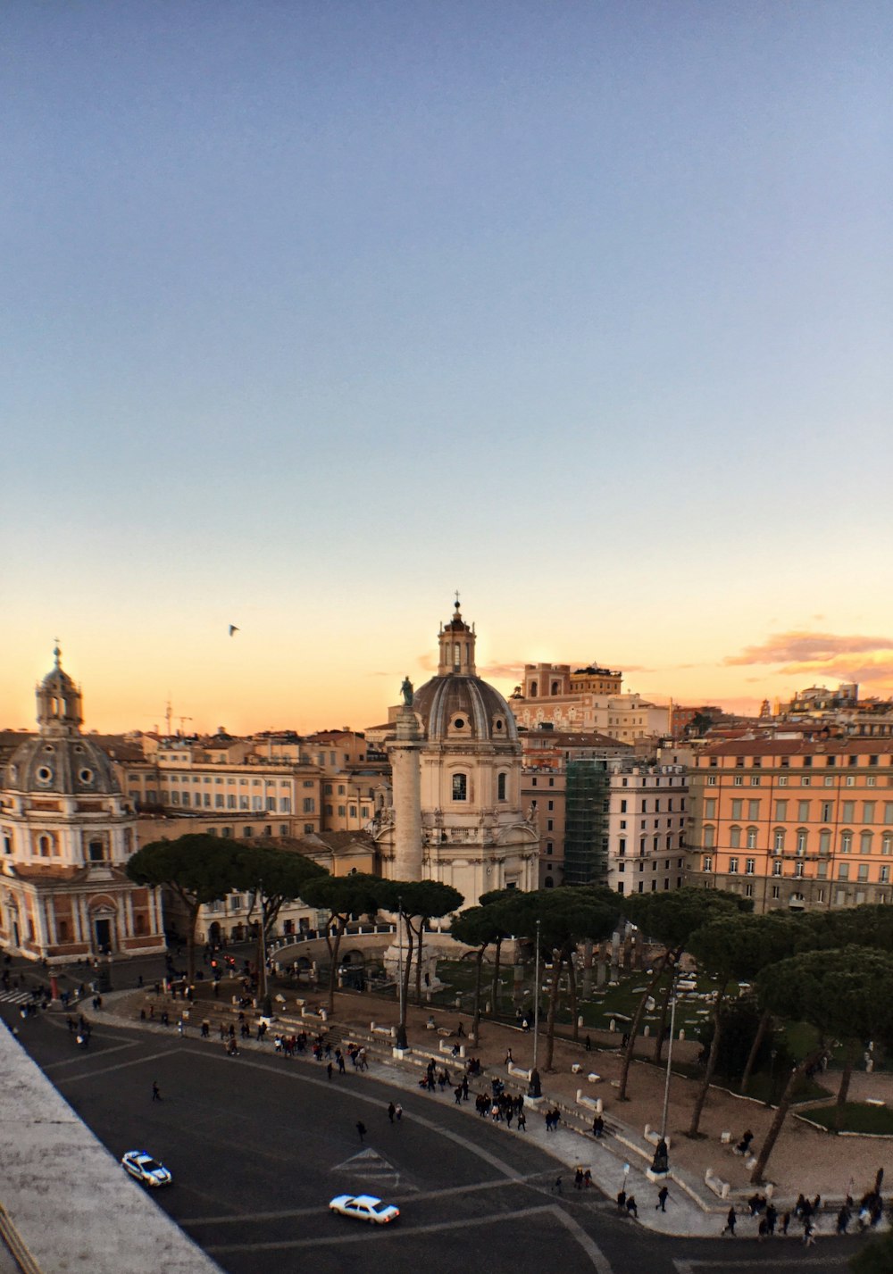 Gente caminando en la calle cerca de los edificios durante la puesta del sol