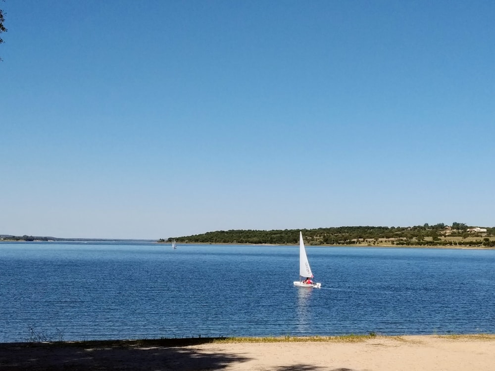 velero blanco en el mar bajo el cielo azul durante el día