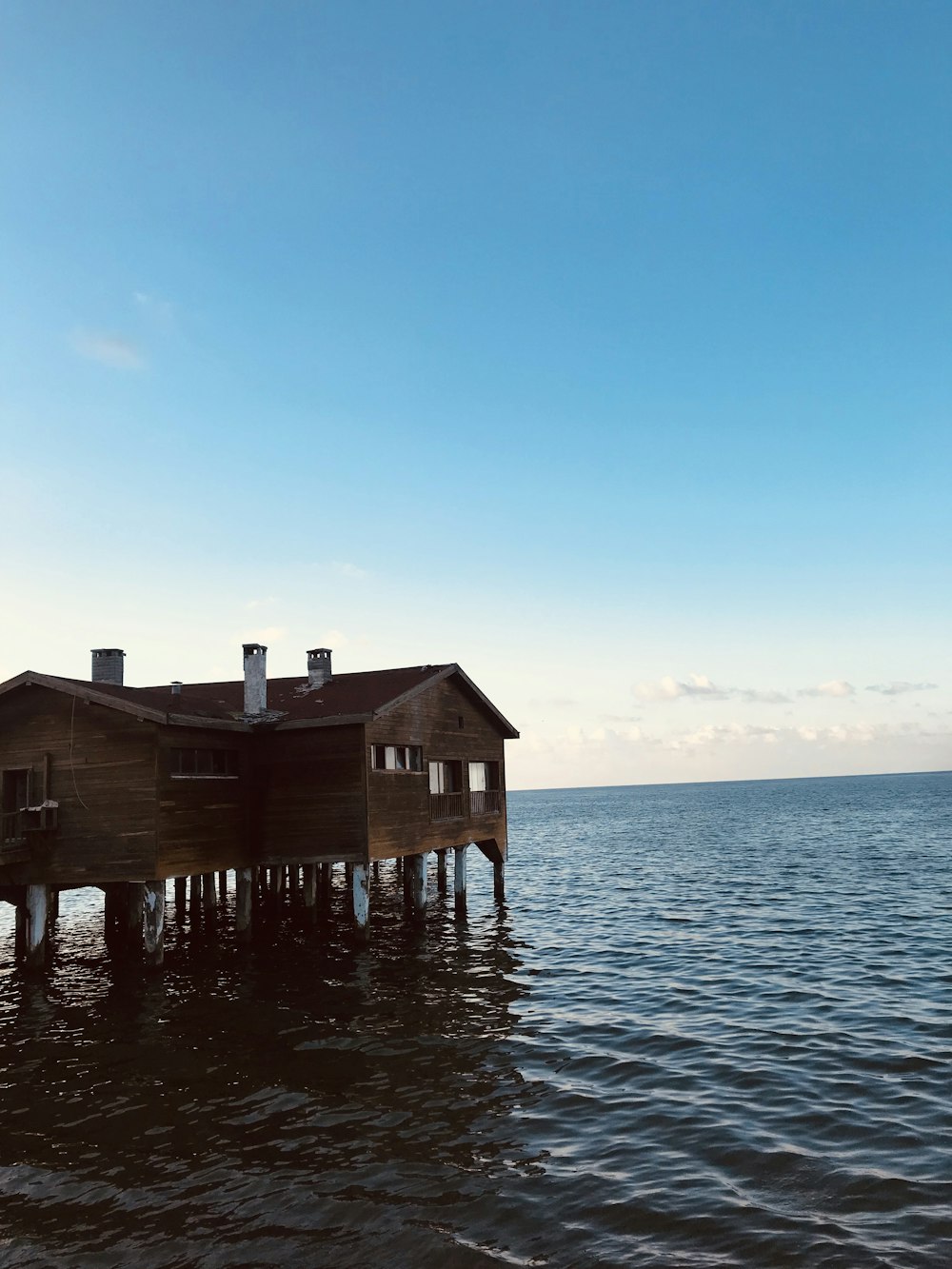 brown wooden house on sea during daytime