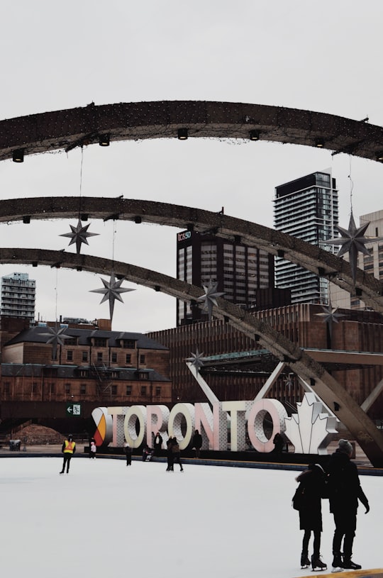 brown and white arch bridge in Nathan Phillips Square Canada
