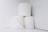 Three rolls of toilet paper are stacked in a minimalist arrangement against a plain white background.