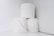 Three rolls of toilet paper are stacked in a minimalist arrangement against a plain white background.