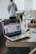 A close-up of a notepad and pen next to a laptop with a website open.