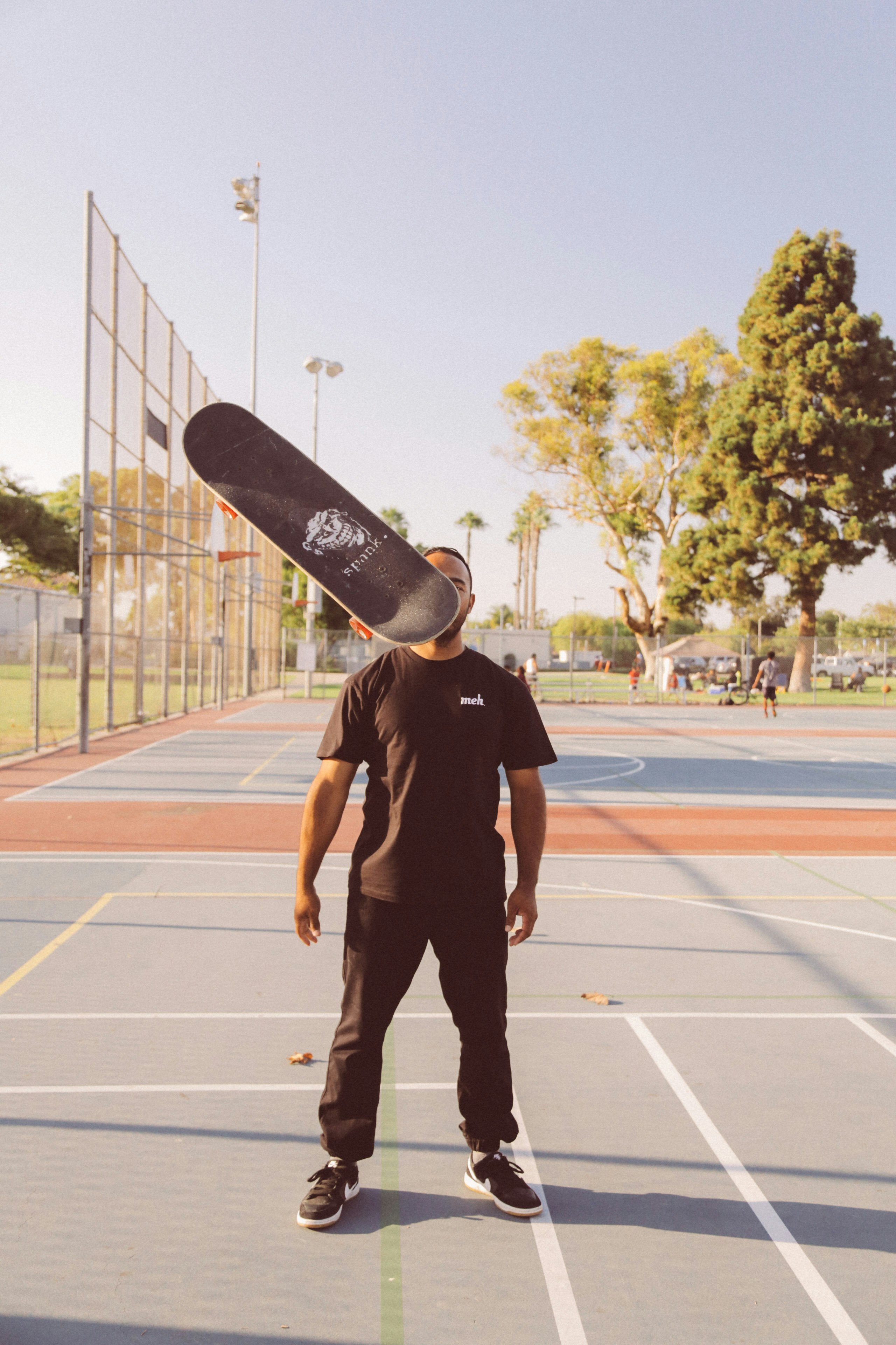 man in black crew neck t-shirt and black pants standing on track field during daytime