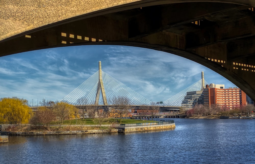 ponte marrom sobre o rio sob o céu azul durante o dia