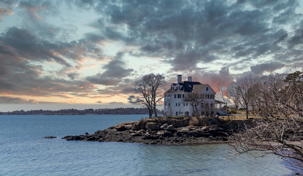 white concrete building near body of water under cloudy sky during daytime