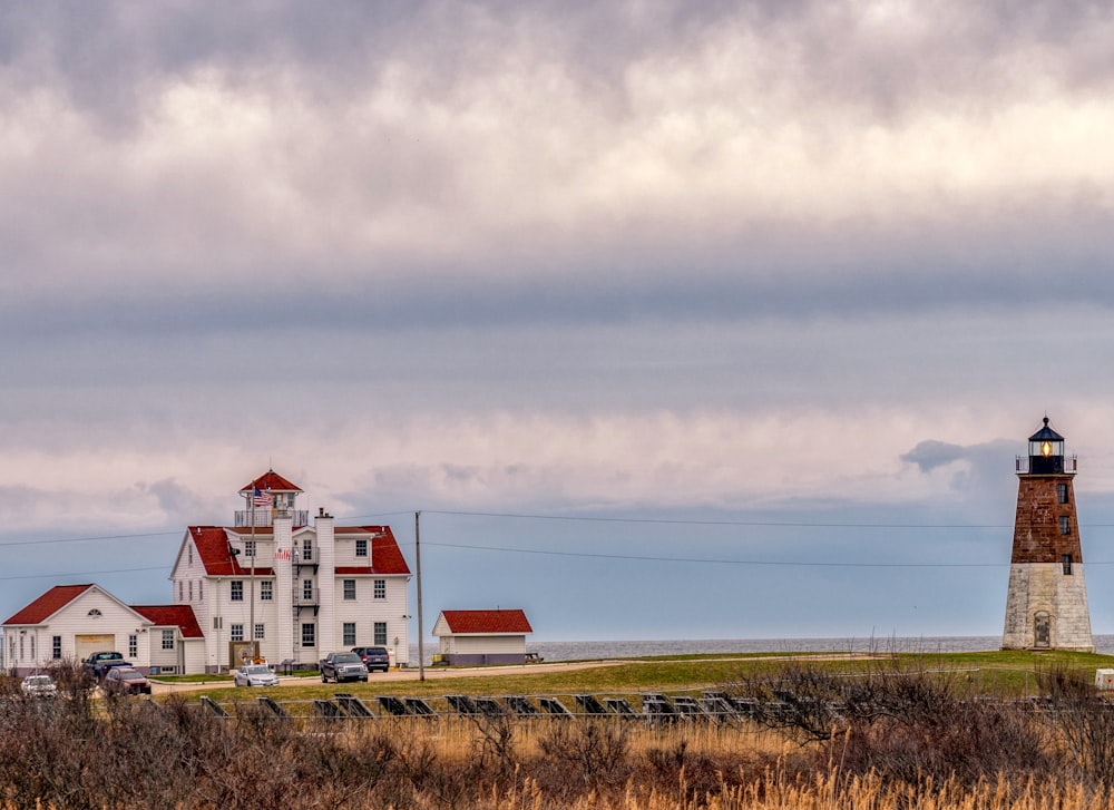 white and red house on green grass field under white clouds during daytime