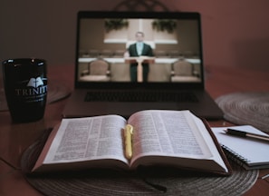 opened book on brown wooden table