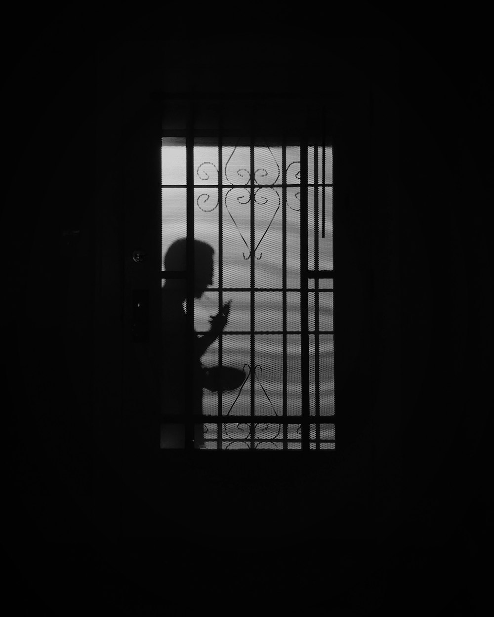 silhouette of person standing on window