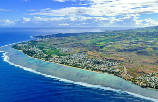 aerial view of green and brown field beside body of water during daytime in La Réunion France