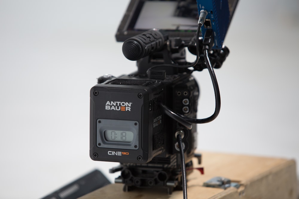 black video camera on brown wooden table