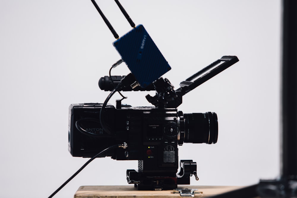 black video camera on brown wooden table