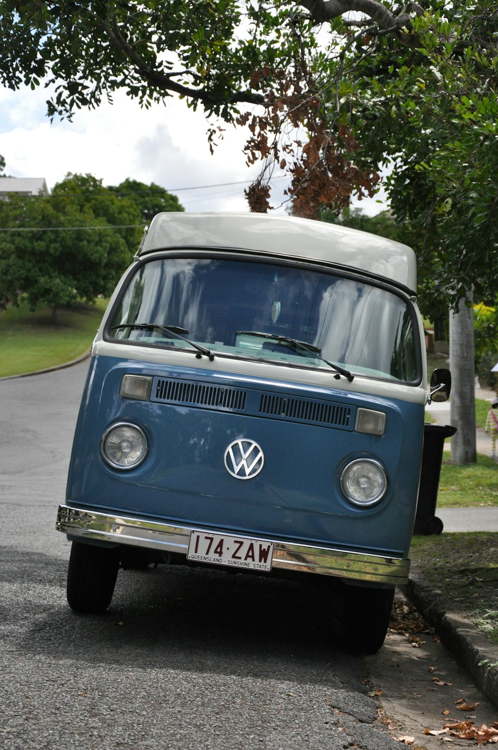 blue and white volkswagen t-2 parked on roadside during daytime