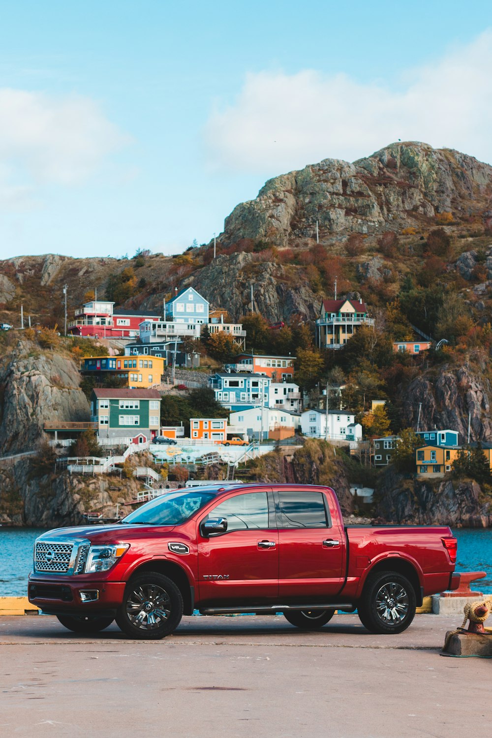 red crew cab pickup truck parked near brown mountain during daytime