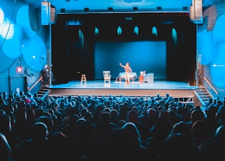 people standing on stage with lights turned on during nighttime