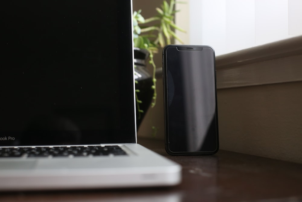 Smartphone negro junto a MacBook Pro