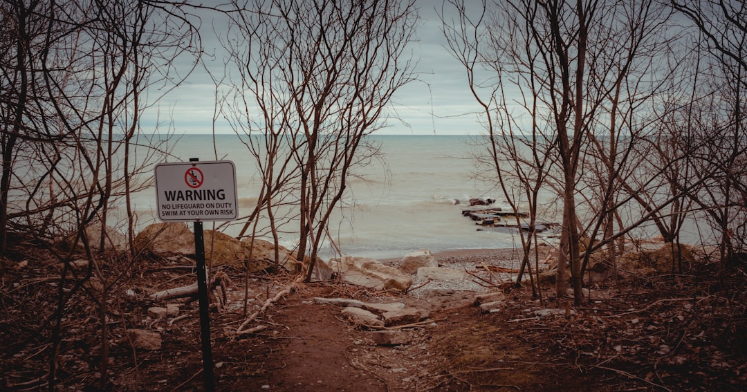 white and black no smoking sign near body of water during daytime