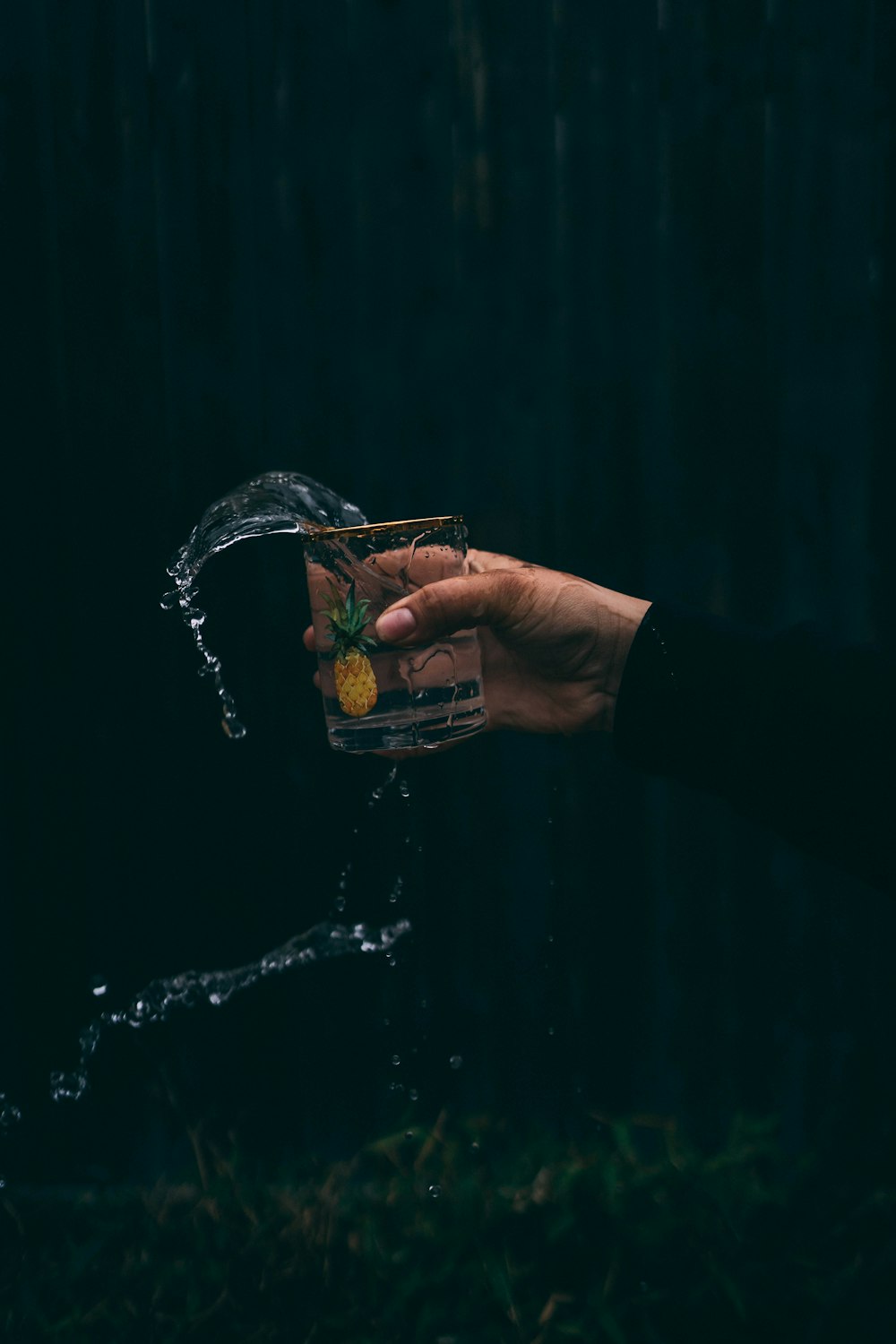 person pouring water on clear drinking glass