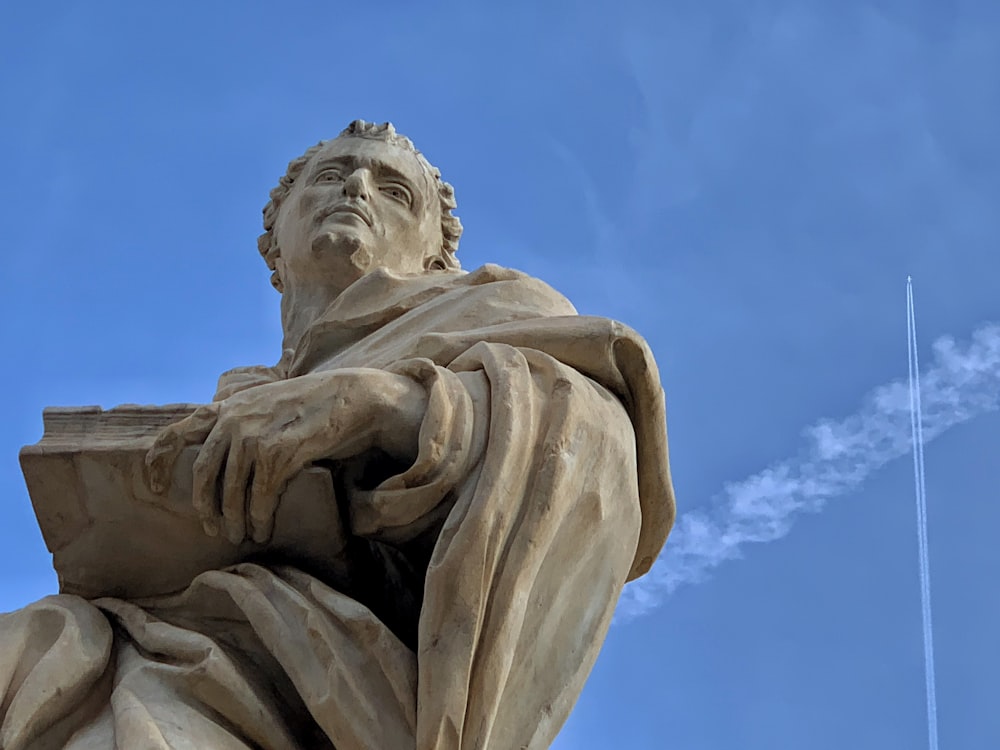 a statue of a man with a book in his hands