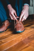 Hands of a child tying shoelaces on a pair of vibrant shoes.