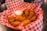 Close-up of a plate filled with crispy chicken wings and dipping sauces on a wooden table.
